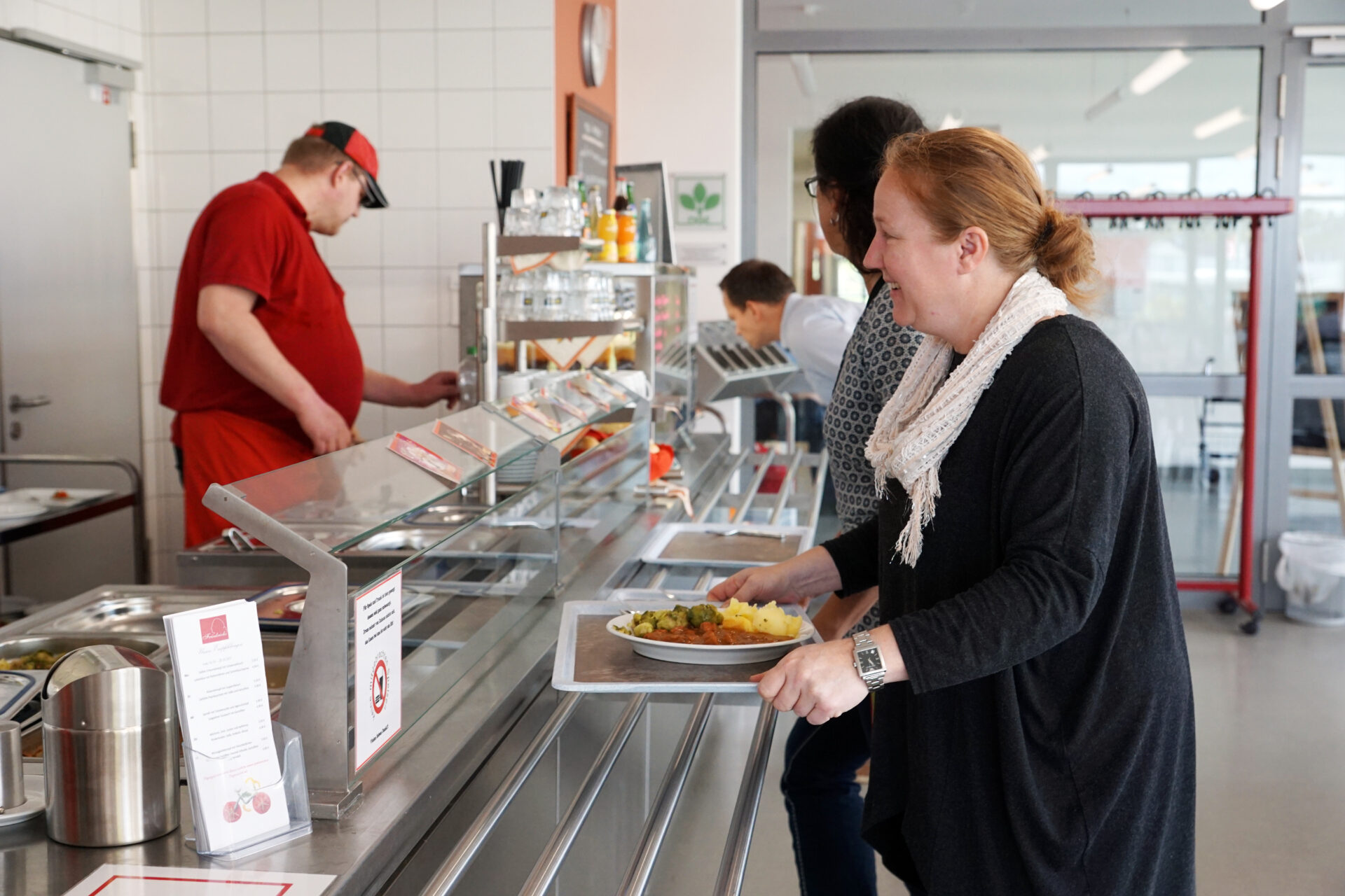 In einer Kantine wird Essen ausgeteilt.