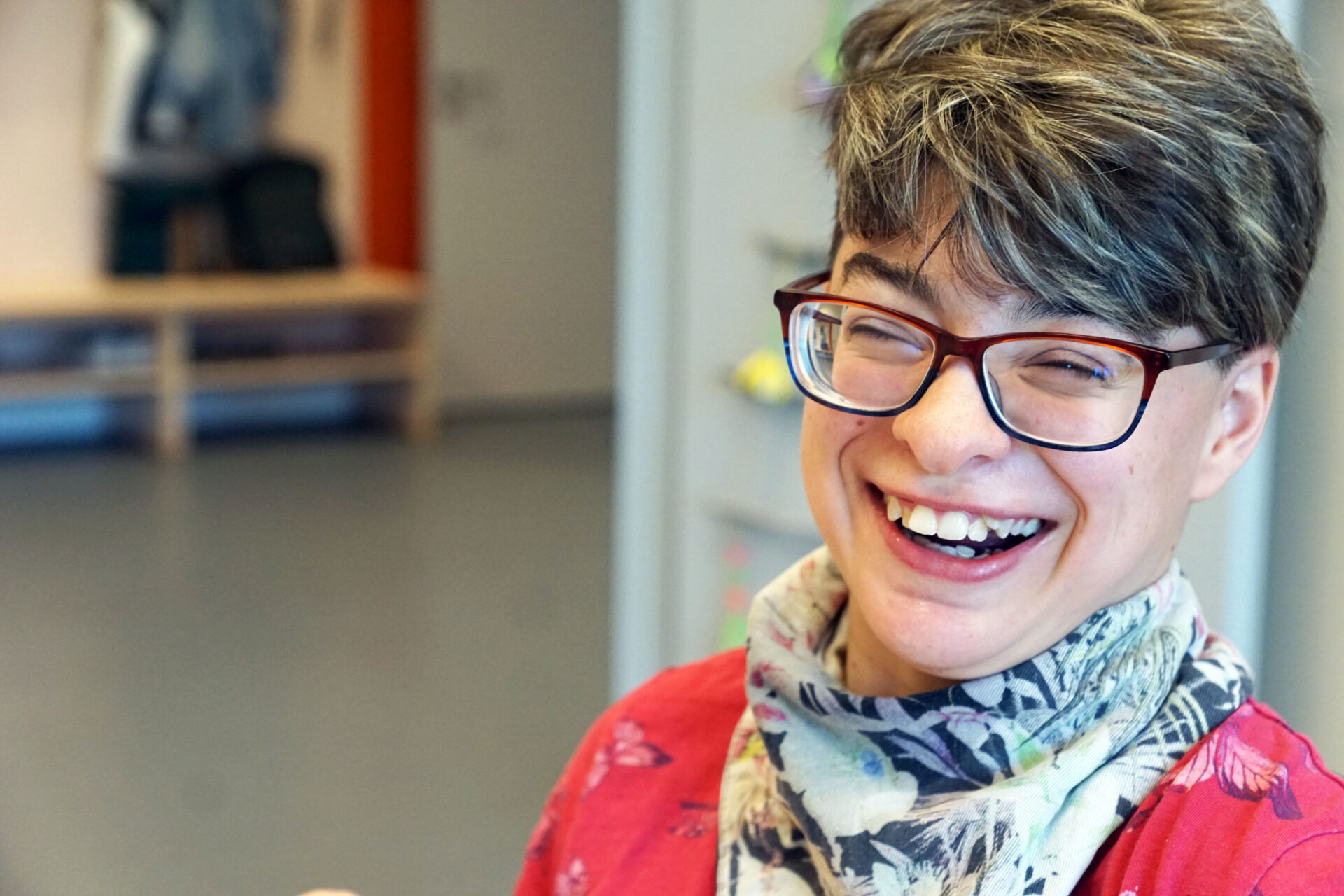 Ein Mädchen mit schwerer Merstfachbehinderung lächelt in die Kamera.