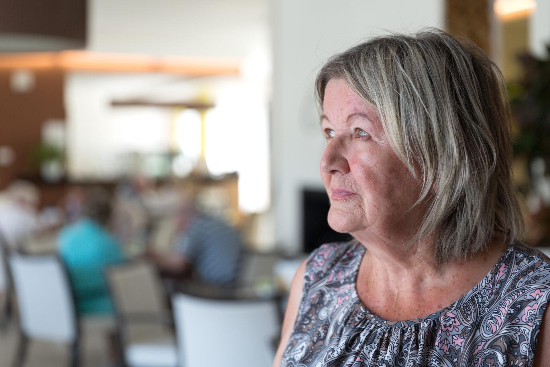 Eine ältere Frau schaut nachdenklich in die Ferne.