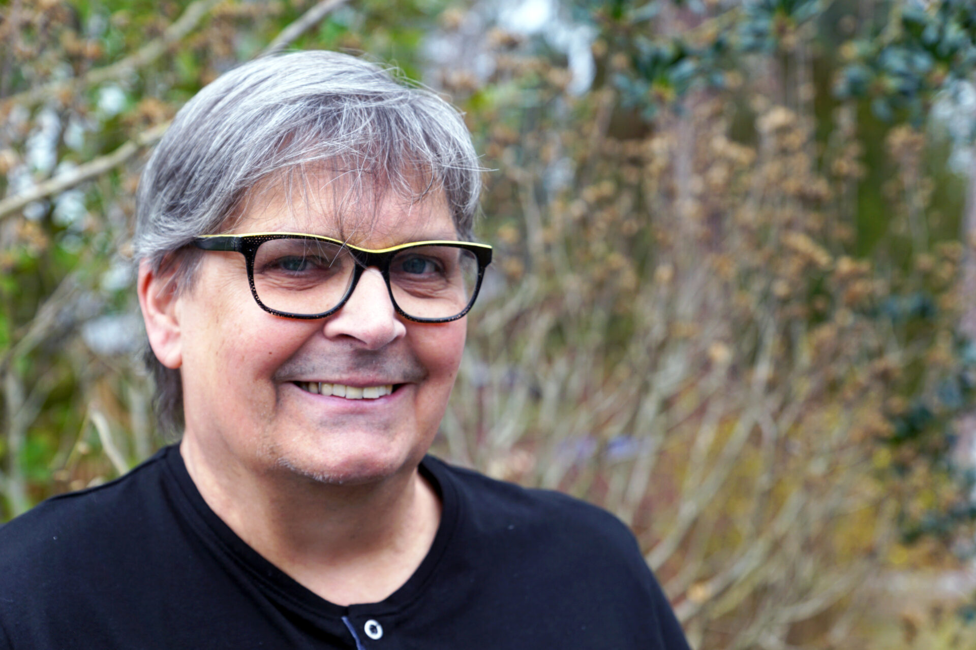 Ein Mann schaut lächelnd in die Kamera.