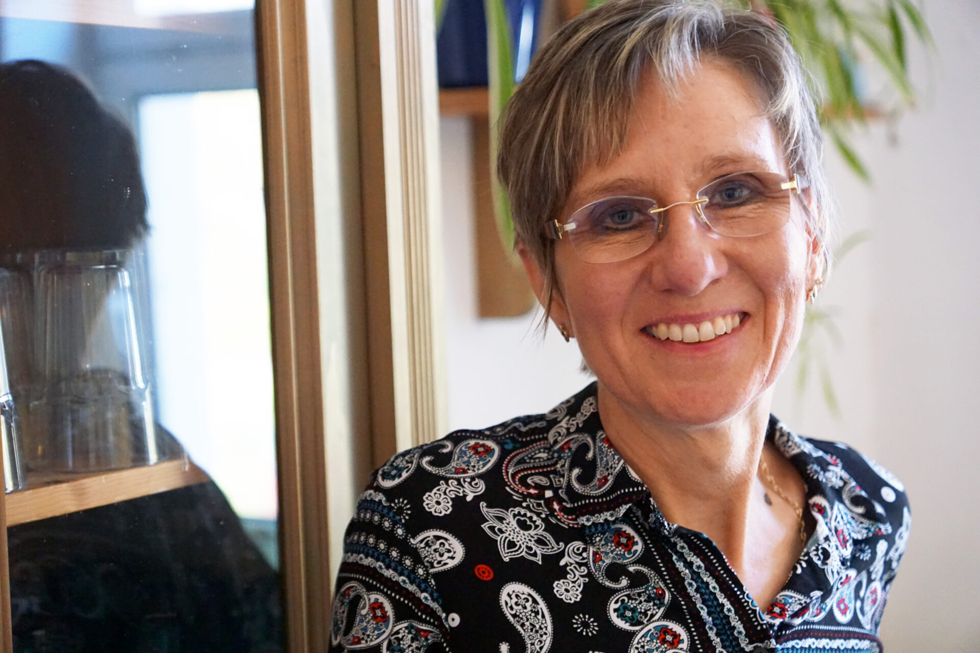 Eine Frau schaut lächelnd in die Kamera.