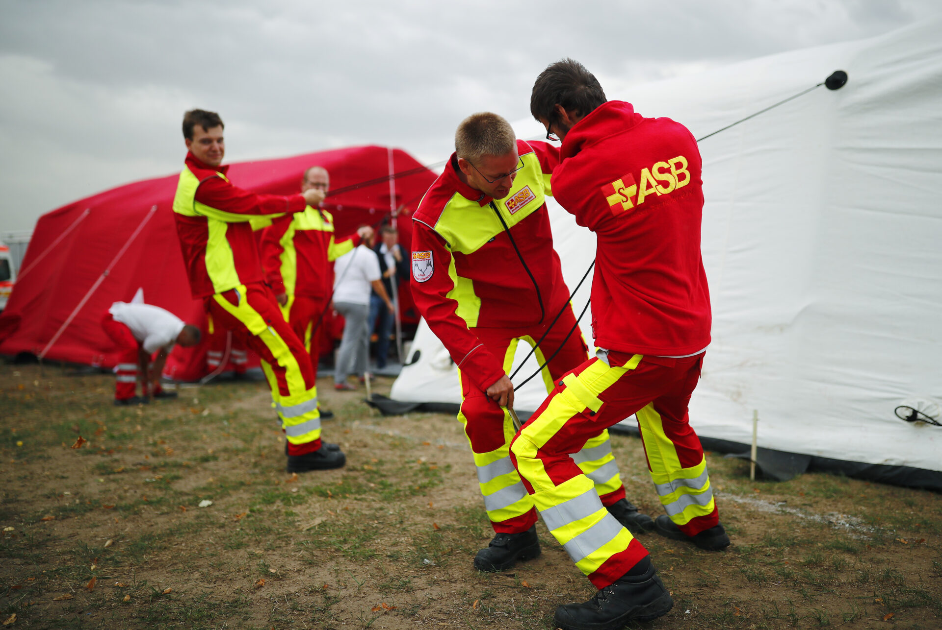 ASB Mitarbeiter bauen ein großes Versorgungszelt auf.