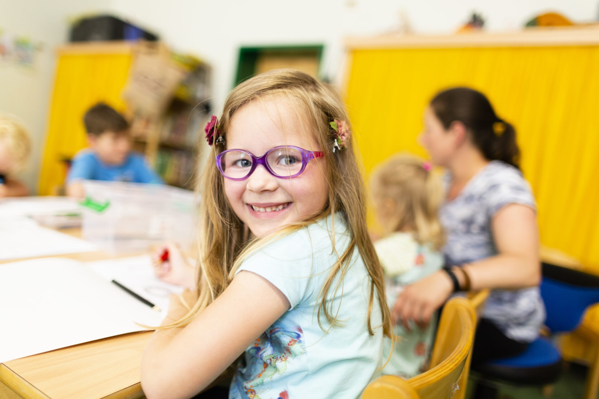 Ein kleines Mädchen strahlt in die Kamera.