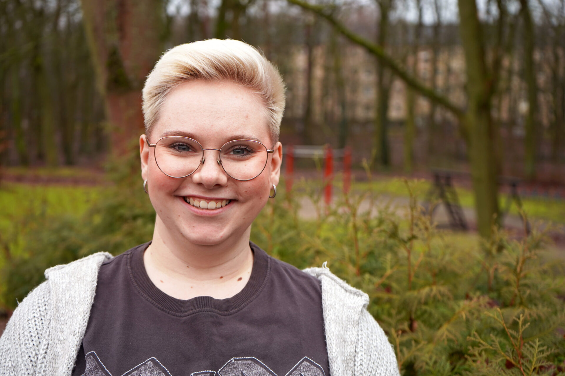 Eine junge Frau schaut lächelnd in die Kamera.